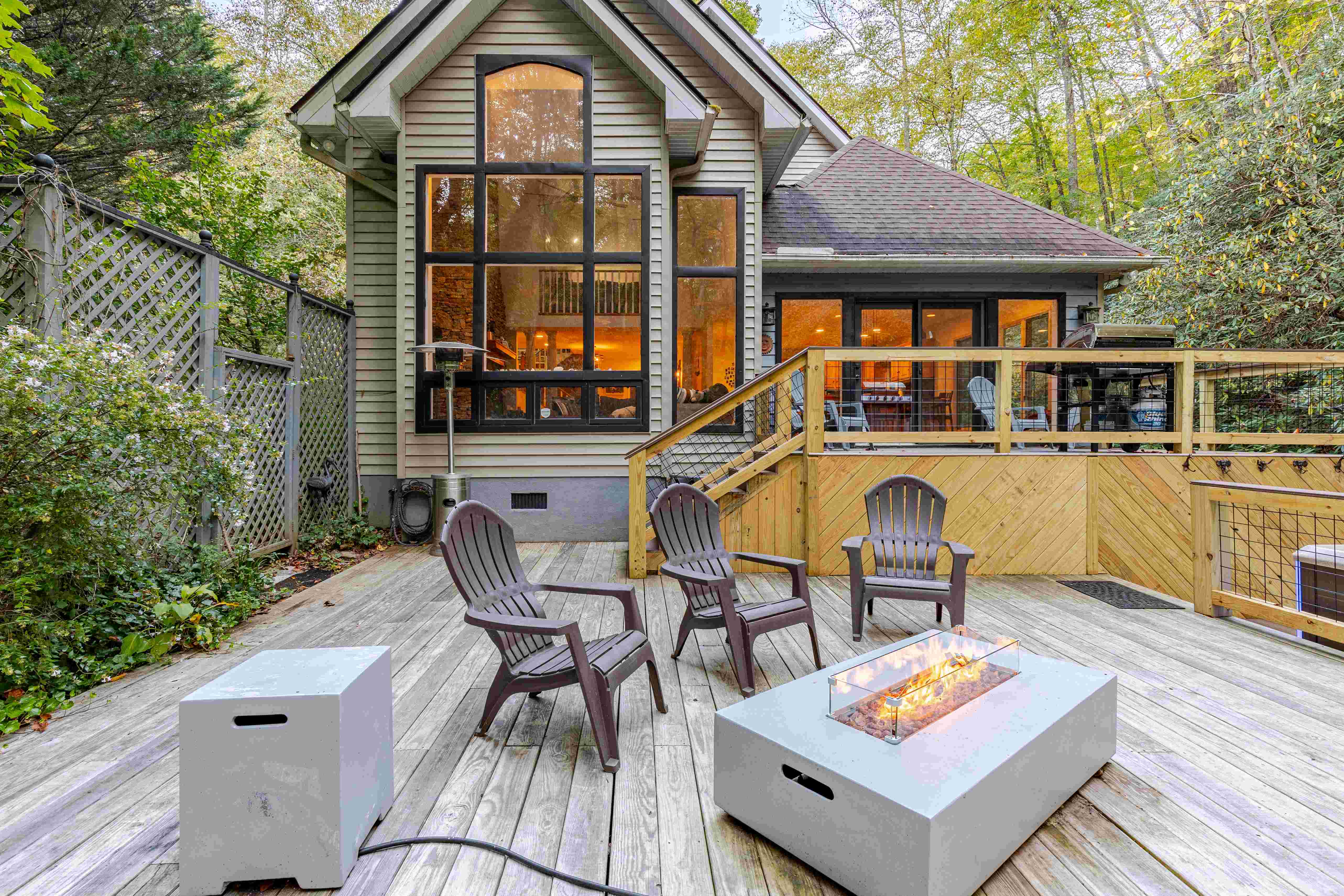 House for sale Franklin NC — rear deck at dusk with fire pit and lit windows